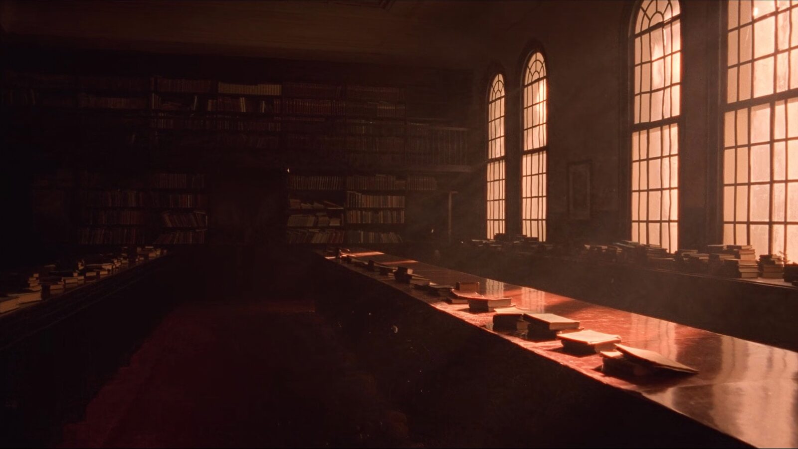 An empty grand university library reading room lit by warm golden-hour light through tall arched windows
