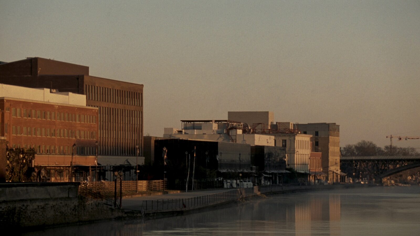 Empty golden-hour riverfront of low brick buildings along the Christina River in Wilmington, Delaware