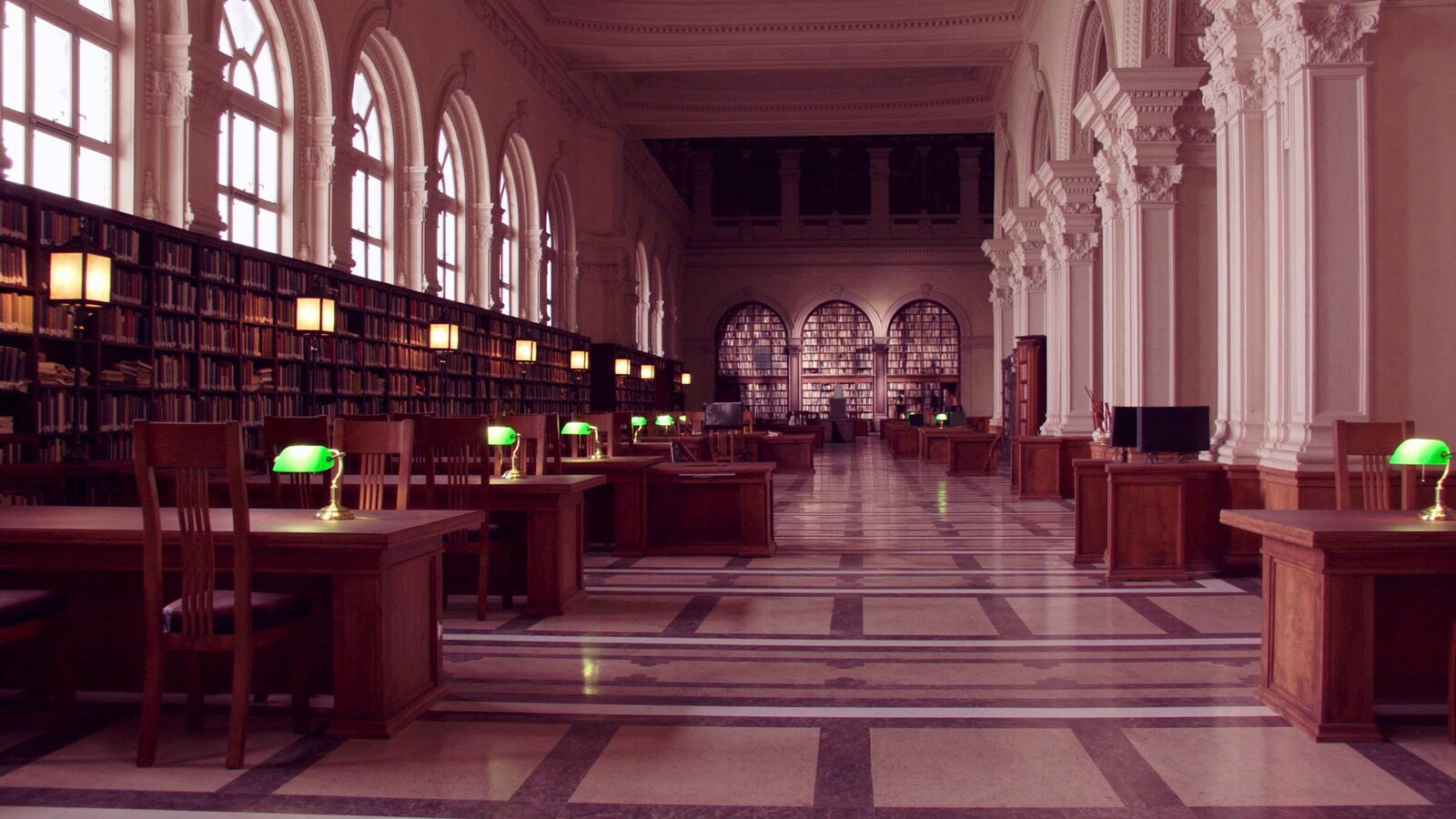 A grand American research library reading room with tall windows and warm light