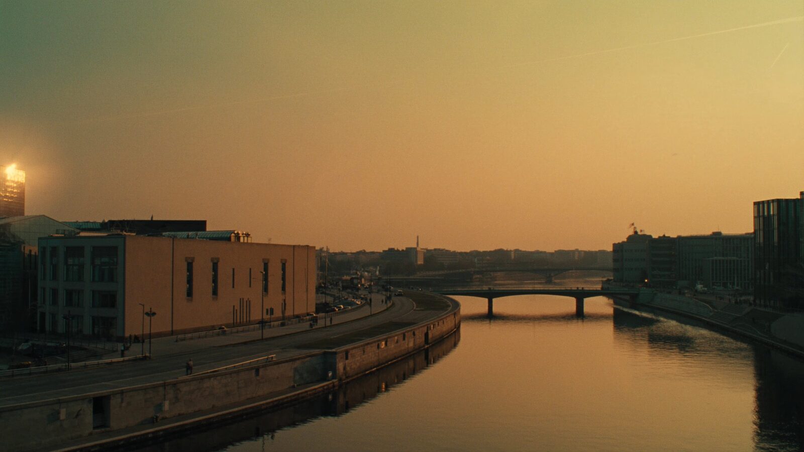Berlin skyline at golden hour along the river Spree with sandstone buildings and a bridge