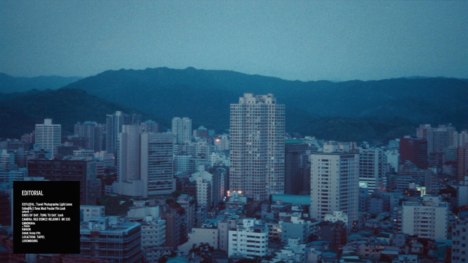 A Taipei skyline with a tall tower rising over the city at blue hour