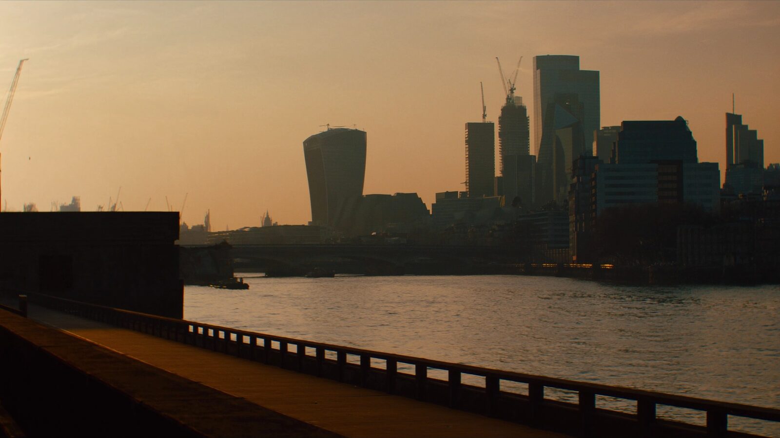 London financial district skyline and the River Thames at golden hour, glass office towers in warm light